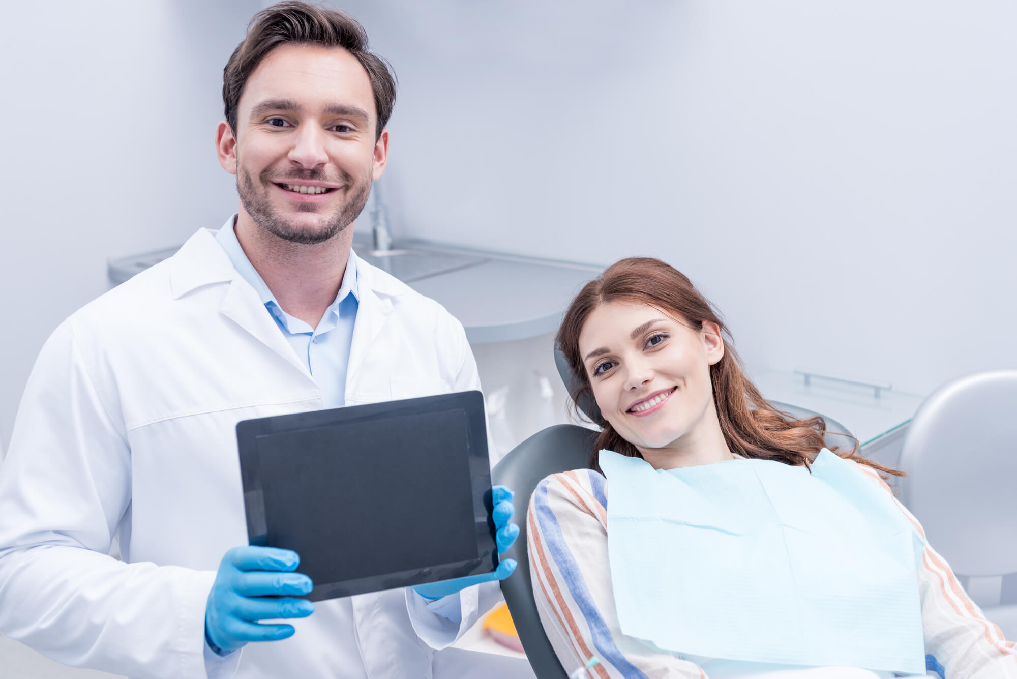 a smiling dentist in Pompano Beach with a patient