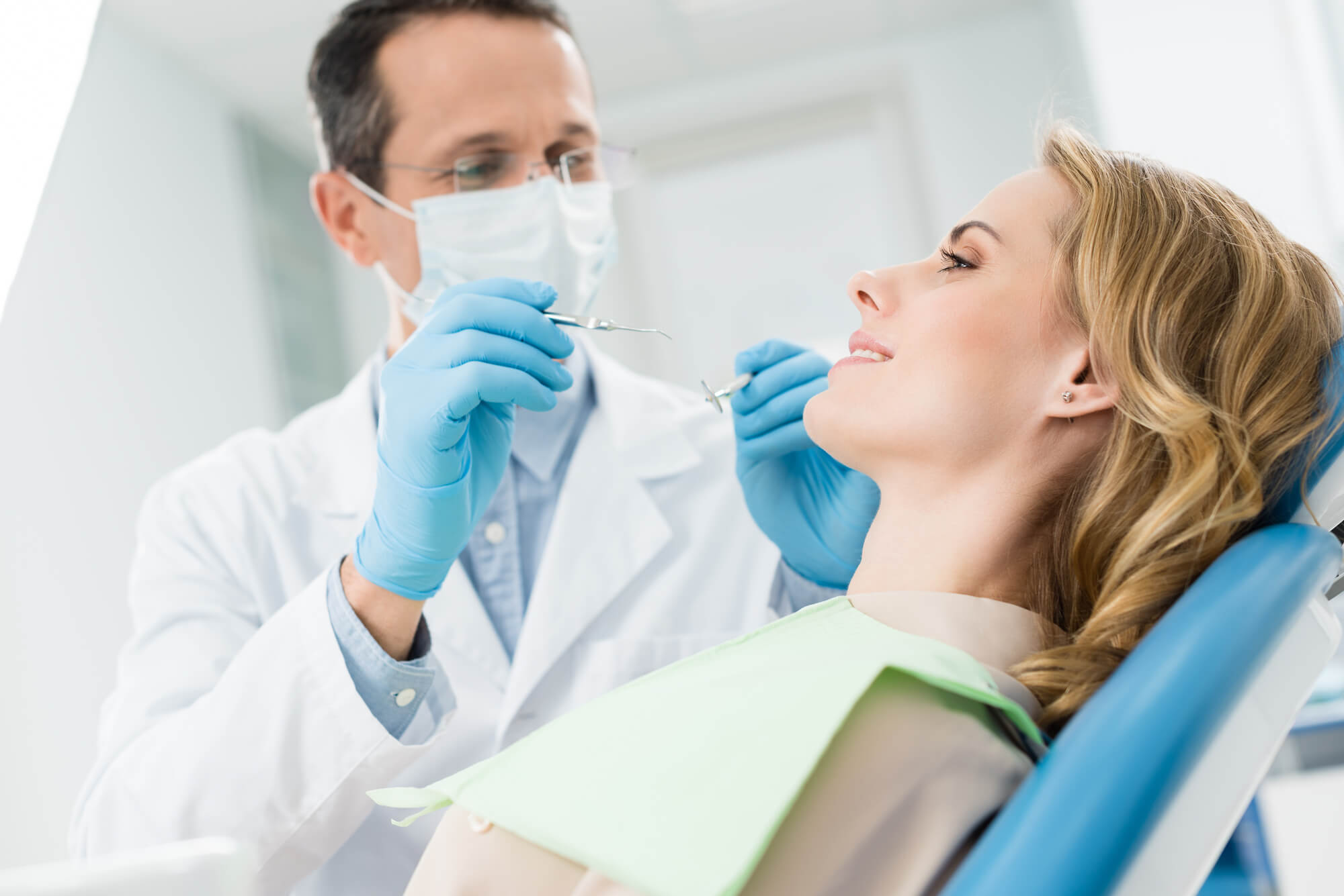 a dentist checking a woman's Dental Implants in 33062
