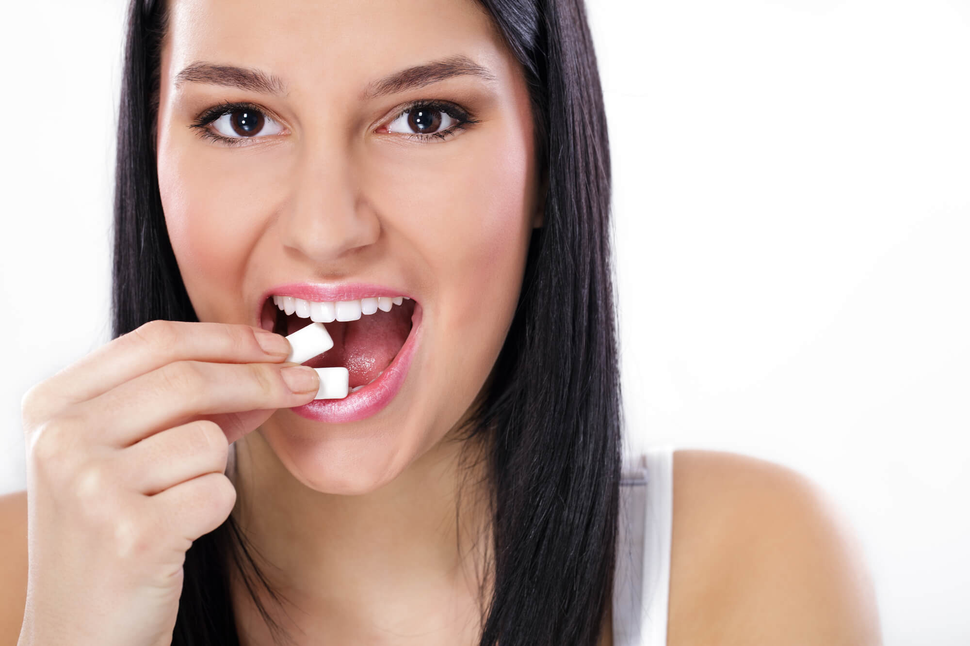 A girl about to chew sugar free gum as advised by her Dentist in Pompano Beach