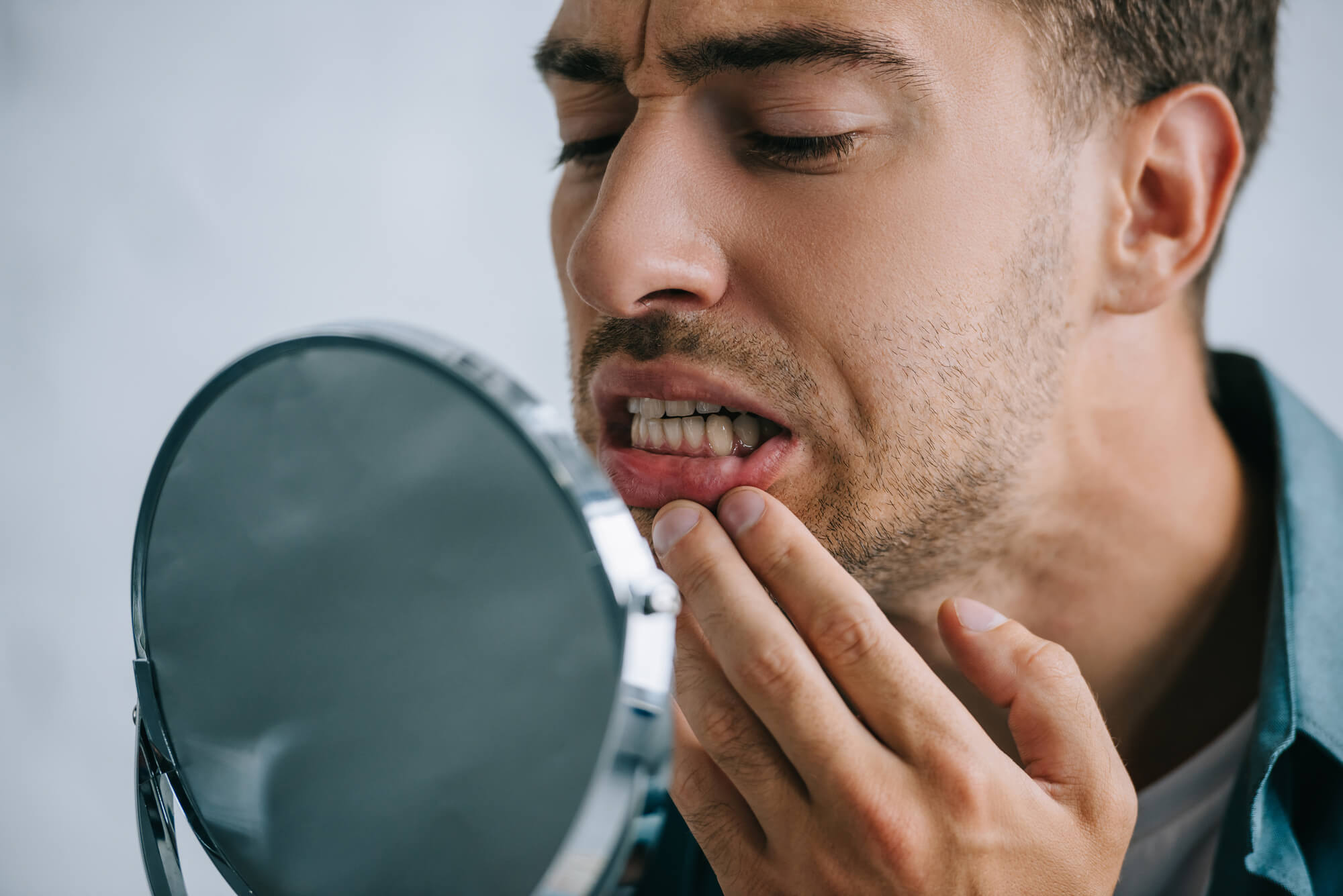 man looking at the mirror after Teeth Whitening in Pompano Beach