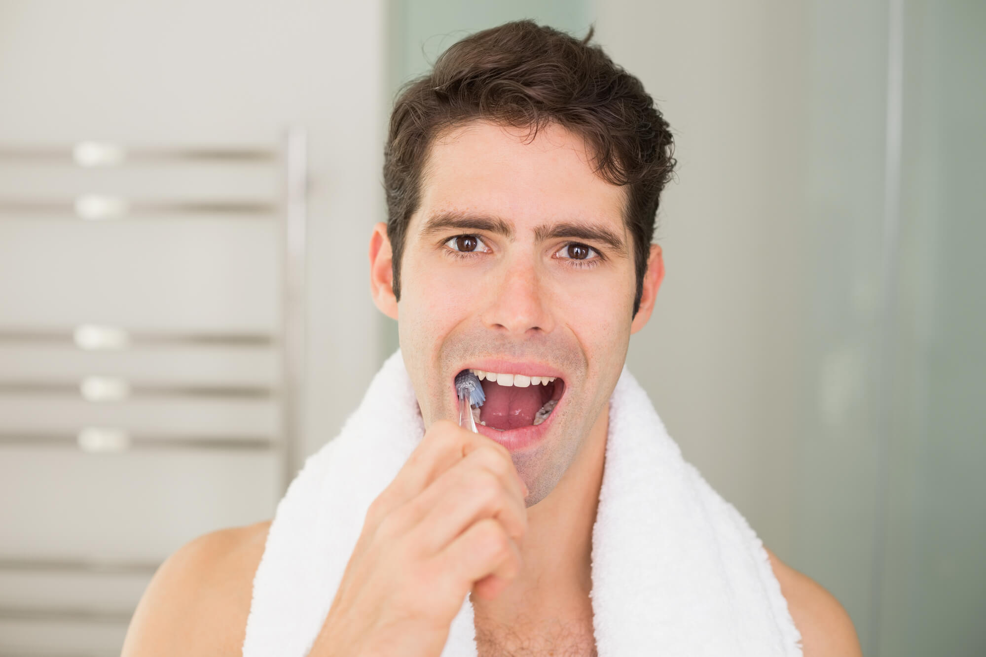 a man uses proper brushing technique as instructed by his Dentist in Pompano Beach
