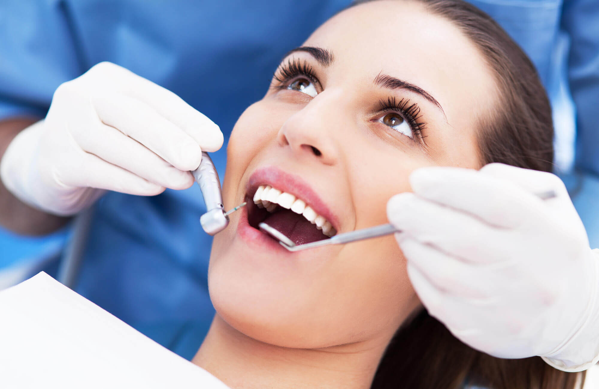 A Dentist in Pompano Beach checks a patient's teeth