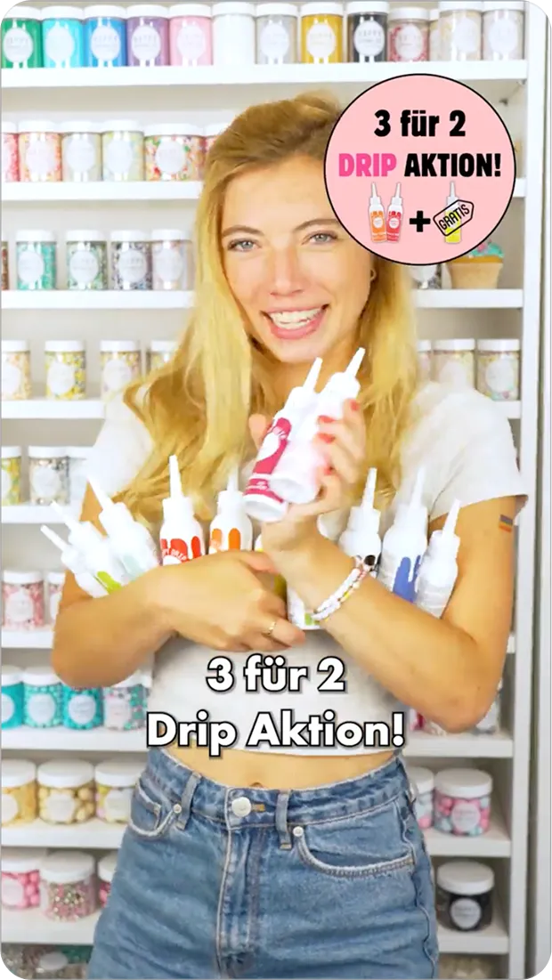 Lächende Frau hält mehrere Drip-Farbtropfenflaschen vor Regalen mit bunten Dekorationsartikeln, Text: 3 für 2 Drip Aktion!