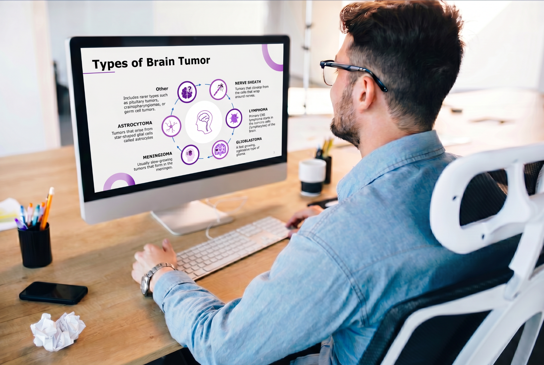Person viewing a brain tumor PowerPoint presentation showing the major types of brain tumors on a desktop monitor.