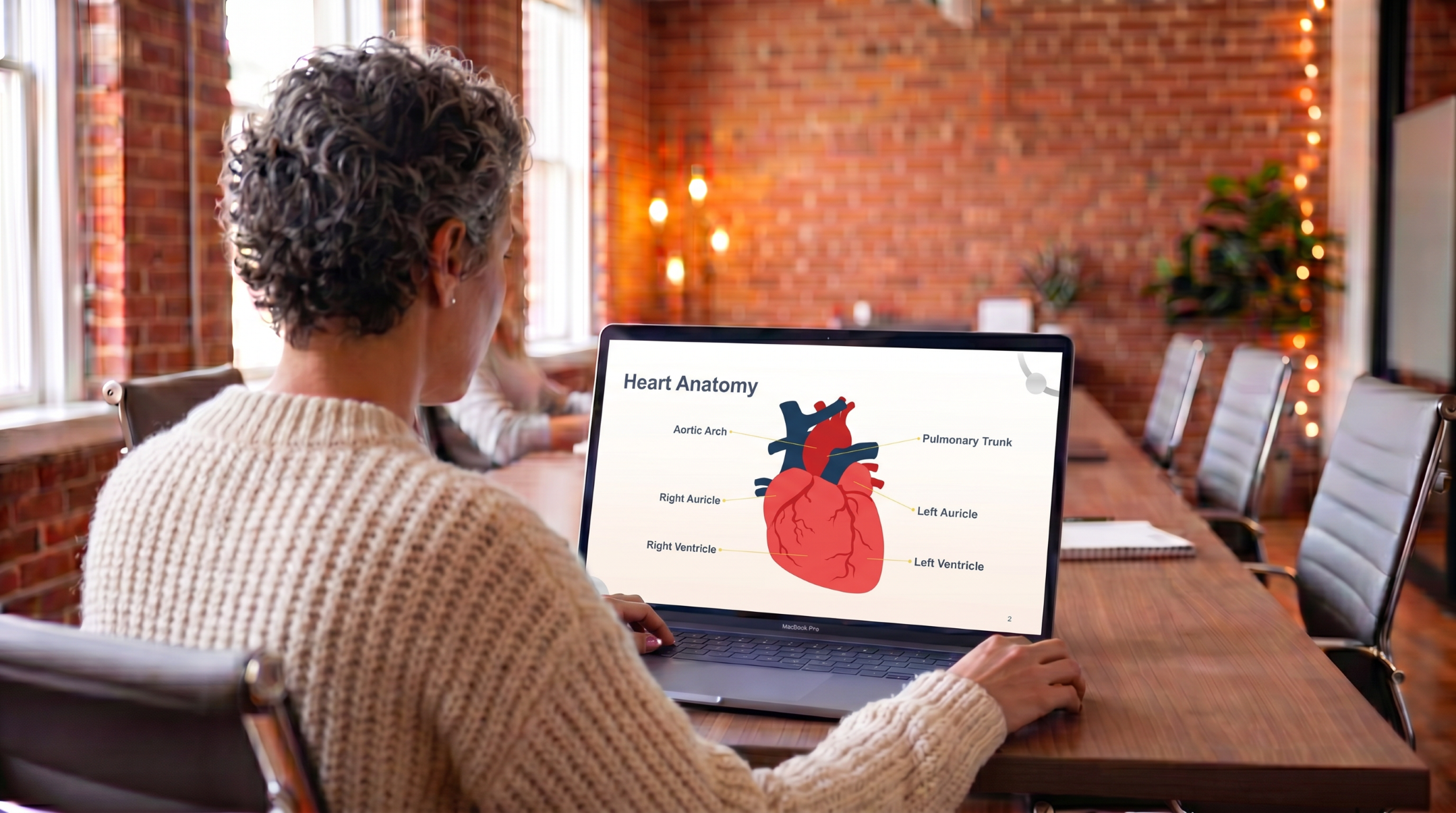 Medical student reviewing heart anatomy using an editable Cardiovascular System Anatomy & Physiology PowerPoint presentation template.