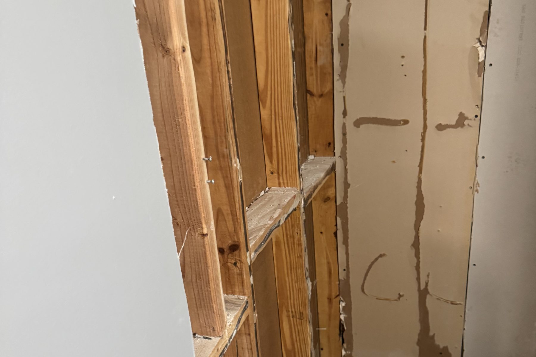 Opened wall cavity showing water-stained framing