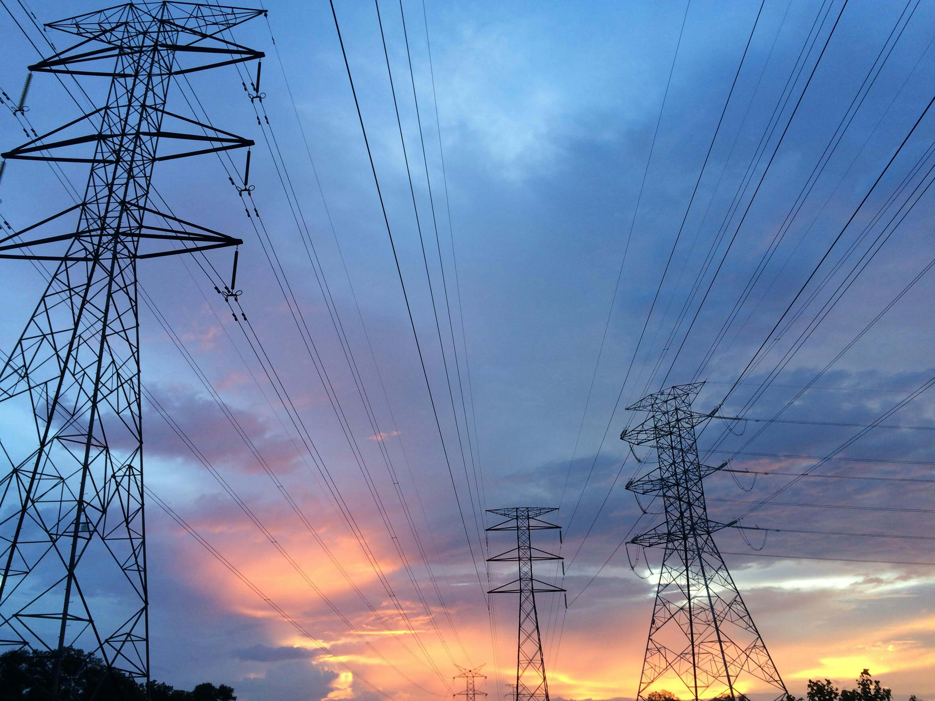 High-voltage power lines and transmission towers at sunset