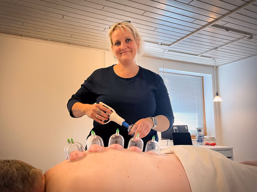 Akupunktør maj brandstrup står og udfører en cuppingbehandling