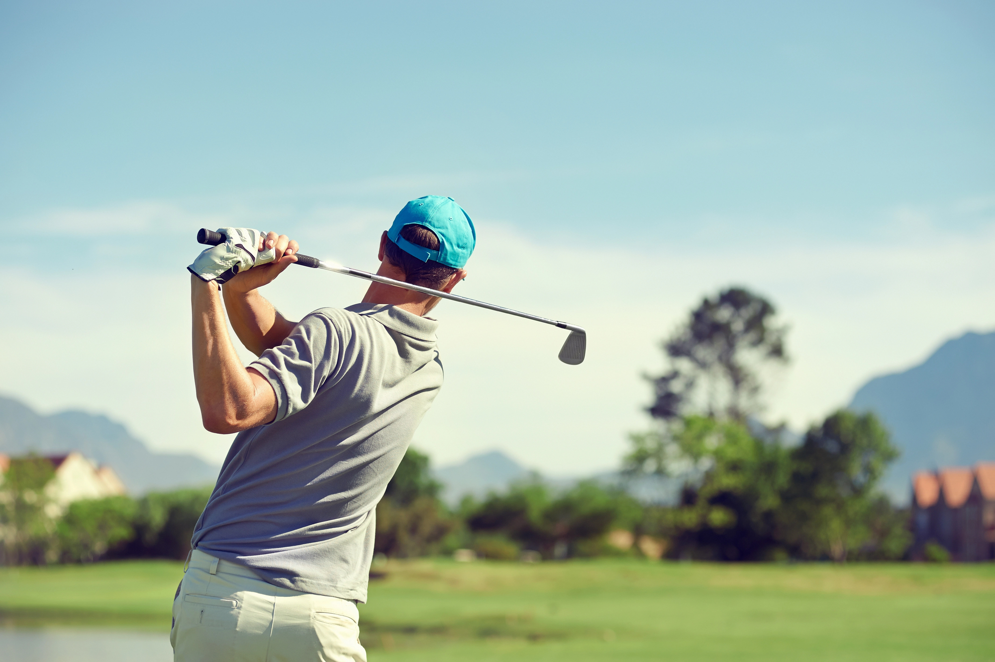 Golfer performing a full golf swing after improving mobility, flexibility and strength through chiropractic and physiotherapy treatment.