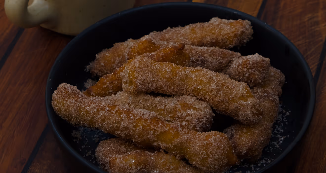 Cinnamon sugar churros served in a black bowl with Mexican café con leche for dessert catering by Carmen’s Tamales