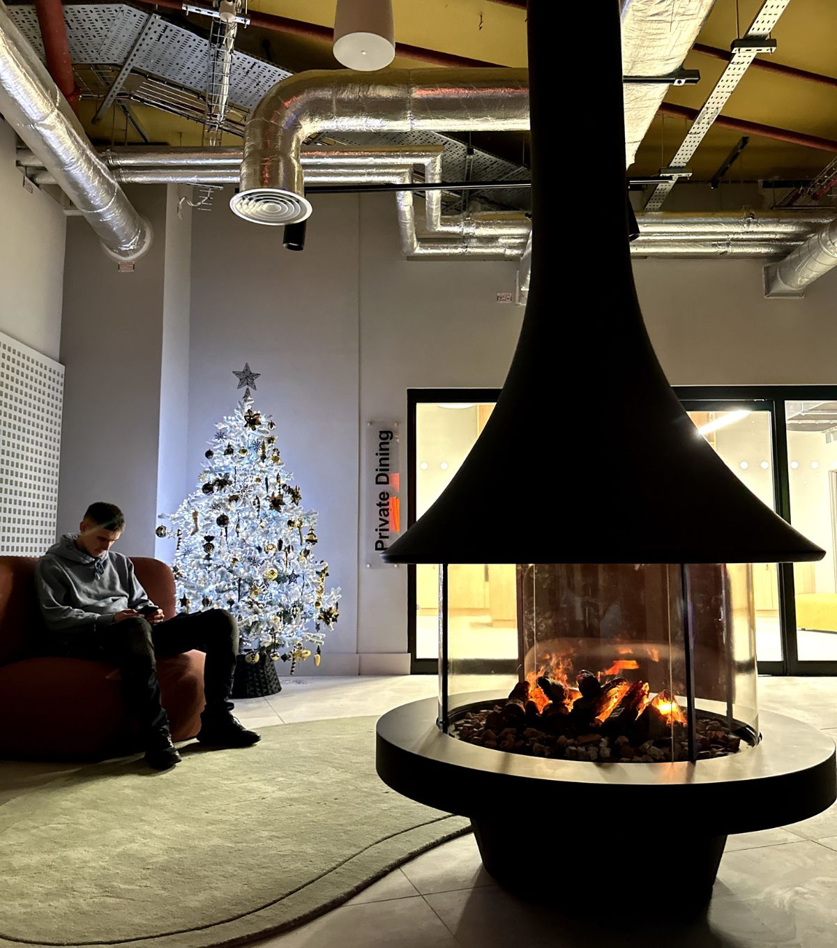 EVA electric effect fireplace with man sat on chair next to