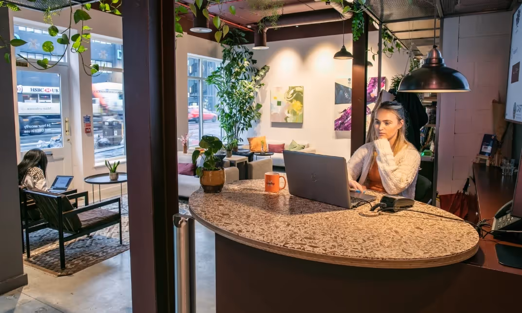 Reception area with coworking space and kitchen facilities.