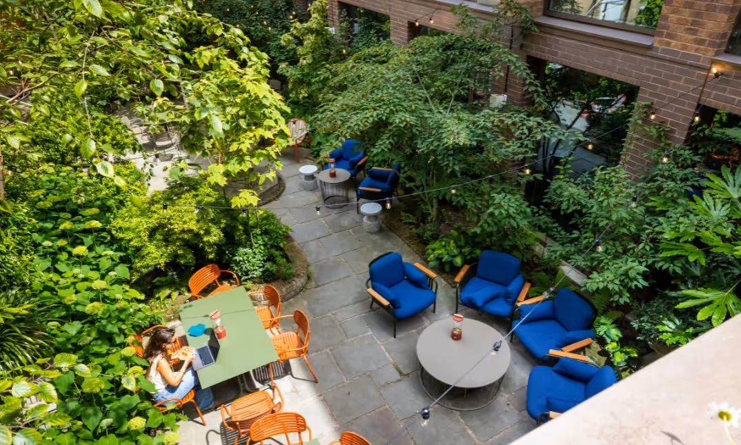 Outdoor courtyard with seating and plants for members to work and relax.