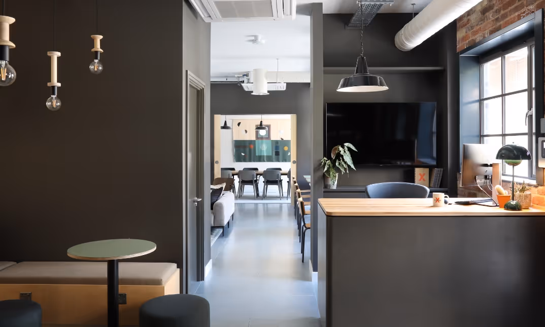 Reception area leading into shared workspace and meeting room area.