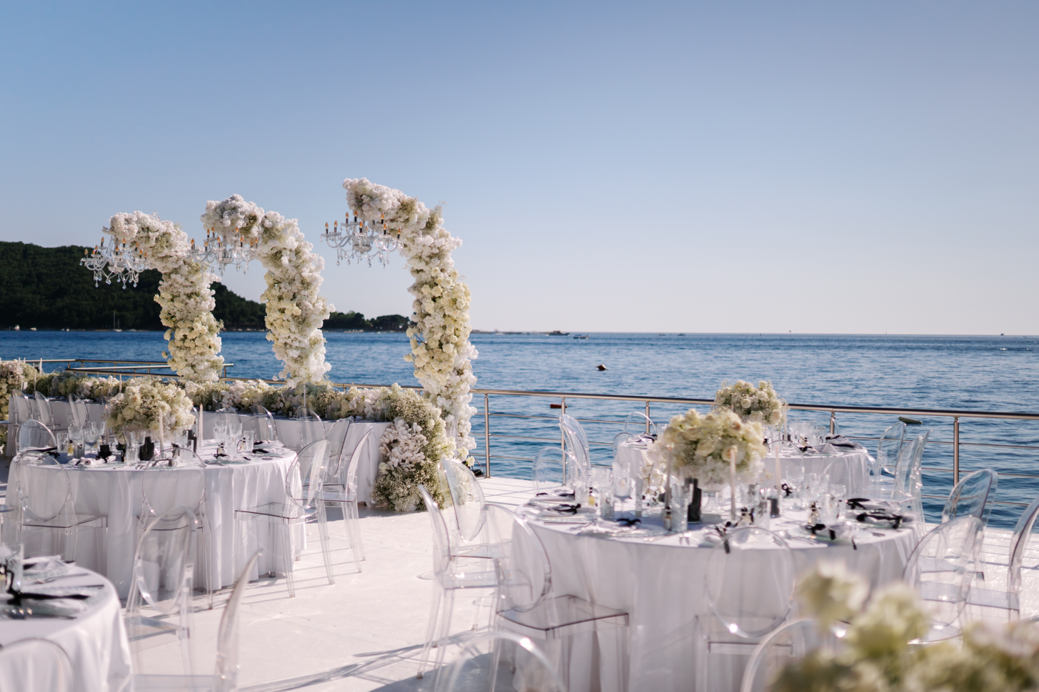 Romantic wedding set-up by the sea at dusk with the view of Adriatic sea and Budva city lights. 