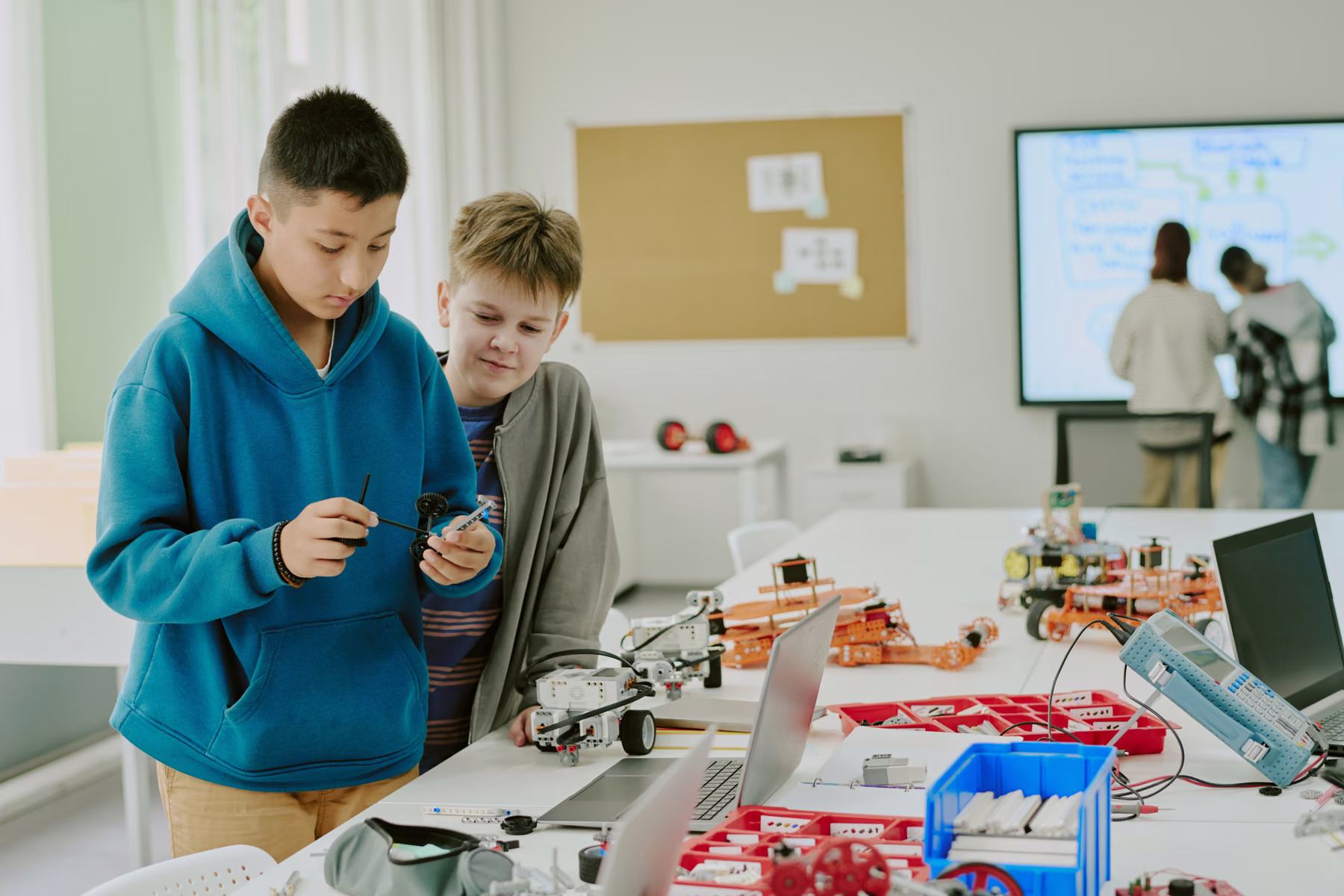 School-age children building a robot together in a classroom