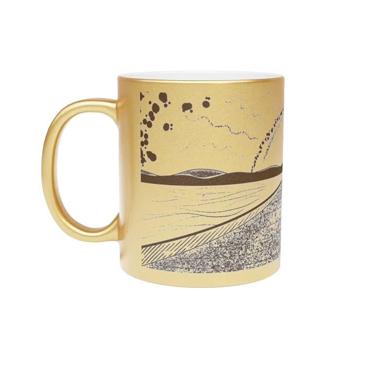 A metallic gold coffee mug depicting a sunset over Maine.