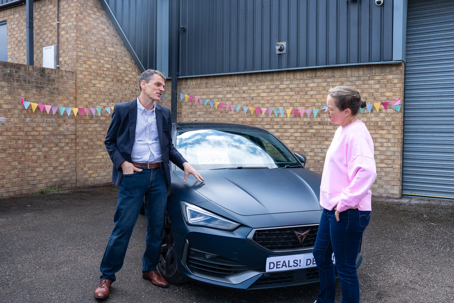 A man and a woman standing next to a car.
