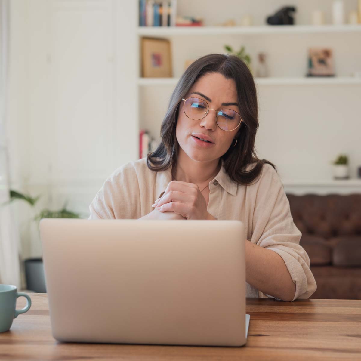 Young woman on laptop at dining room table