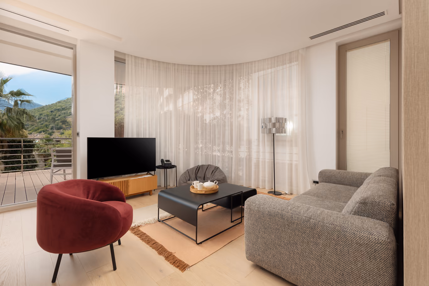 Beautifully decorated living room in a three-bedroom apartment with a view of Dukley Gardens and Montenegrin mountains.