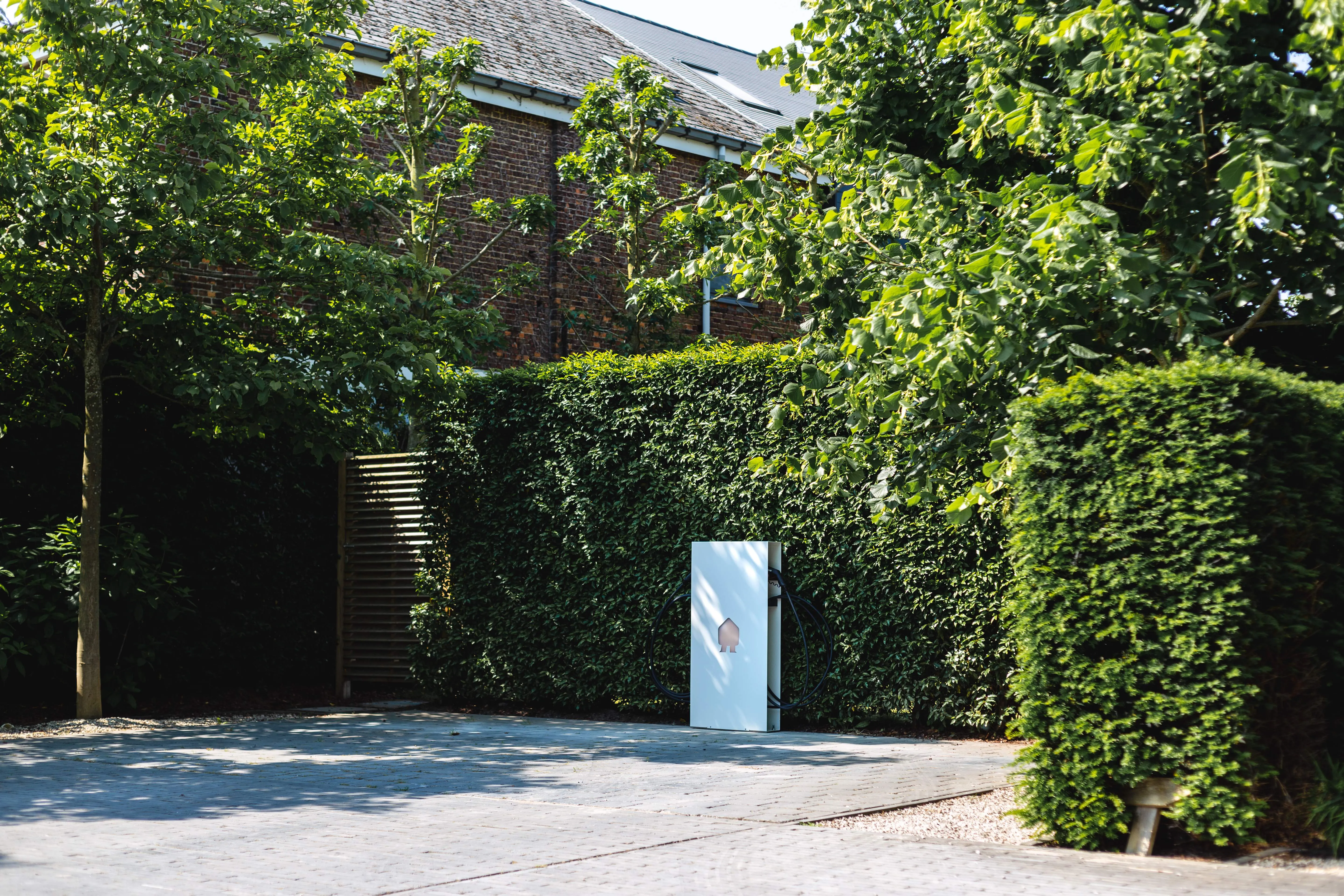 A blue box sitting in the middle of a sidewalk.