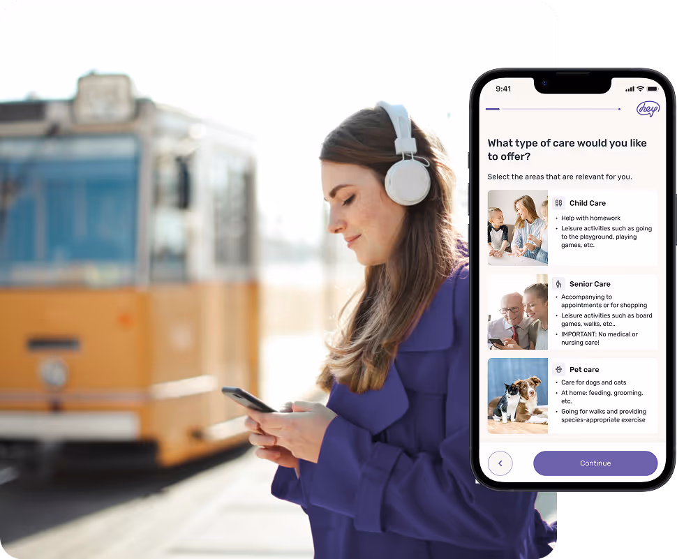 A young woman with headphones stands in front of a tram and looks at her smartphone. In addition, the HEYCARE app is open with a selection of types of care: childcare, care for the elderly and pet care.