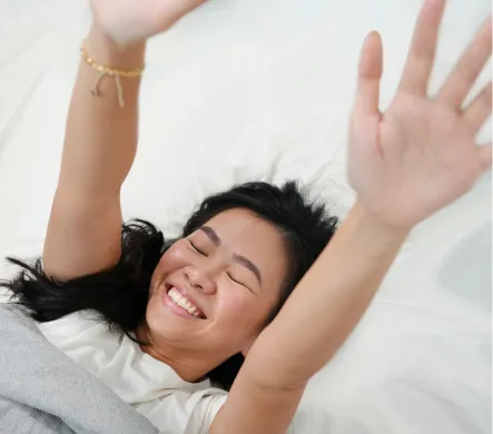 A woman happily waking up from sleep