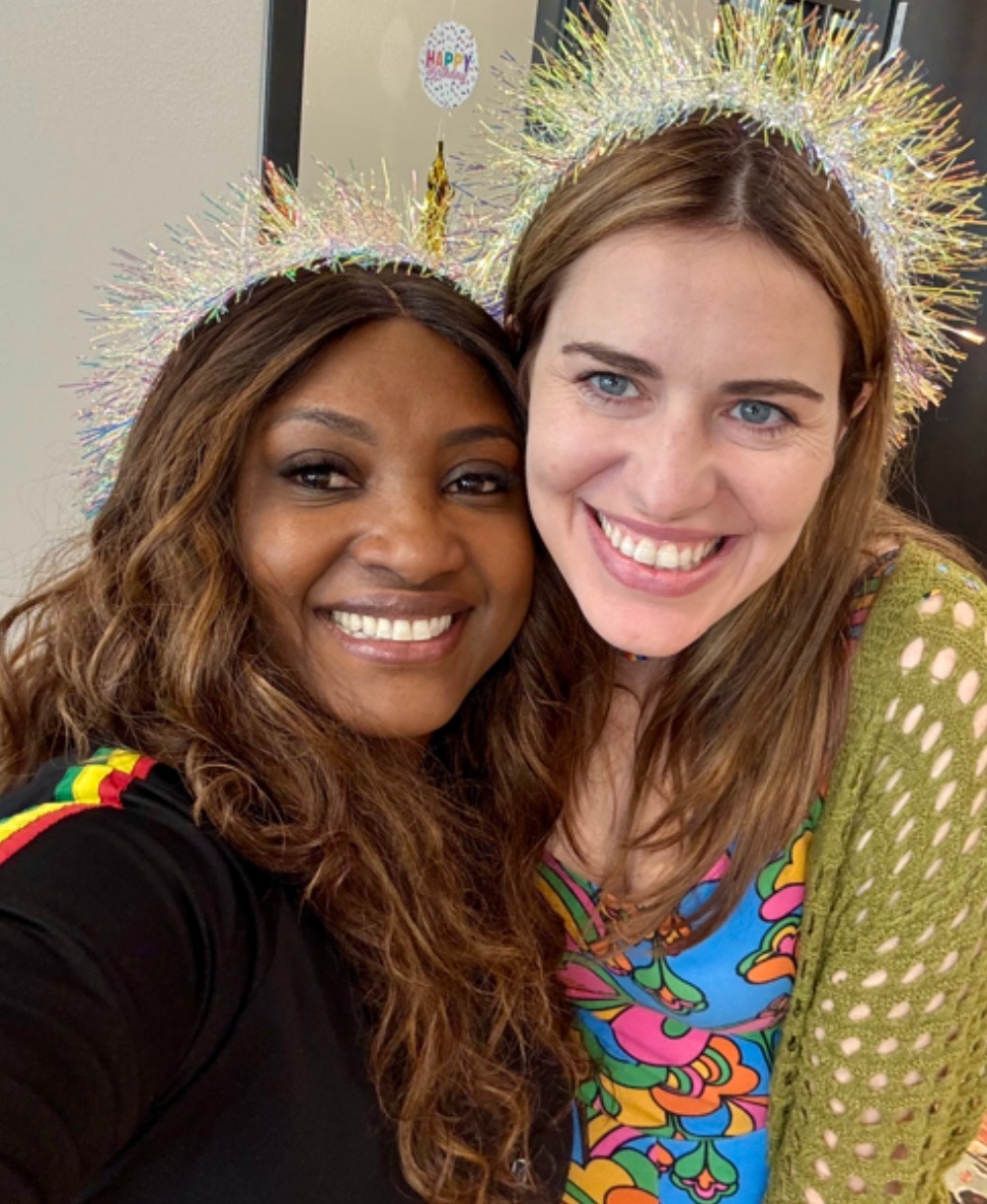 Rochelle Bradshaw and Amanda Strickland, CEO of The Source cannabis dispensary celebrating with tinsel party crowns at an event.