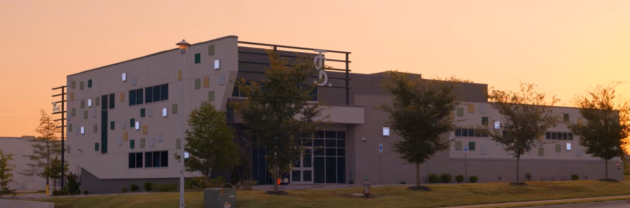 The Source Craft Cannabis dispensary building exterior at sunset in Rogers, Arkansas