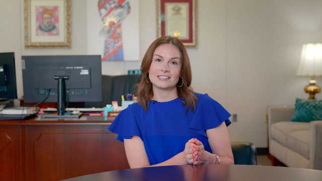 Christy Bjornson from Arkansas Alcoholic Beverage Control sitting for interview in blue dress for Roots & Reefer documentary.