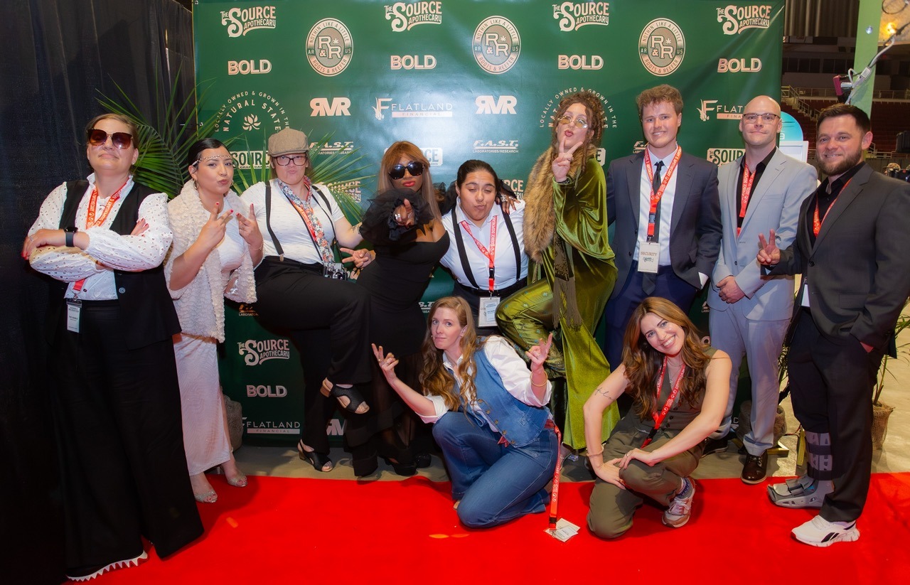 Cast and crew of Roots & Reefer documentary posing on red carpet at YouTube premiere event with sponsor logos including The Source, BOLD, and River Valley Relief