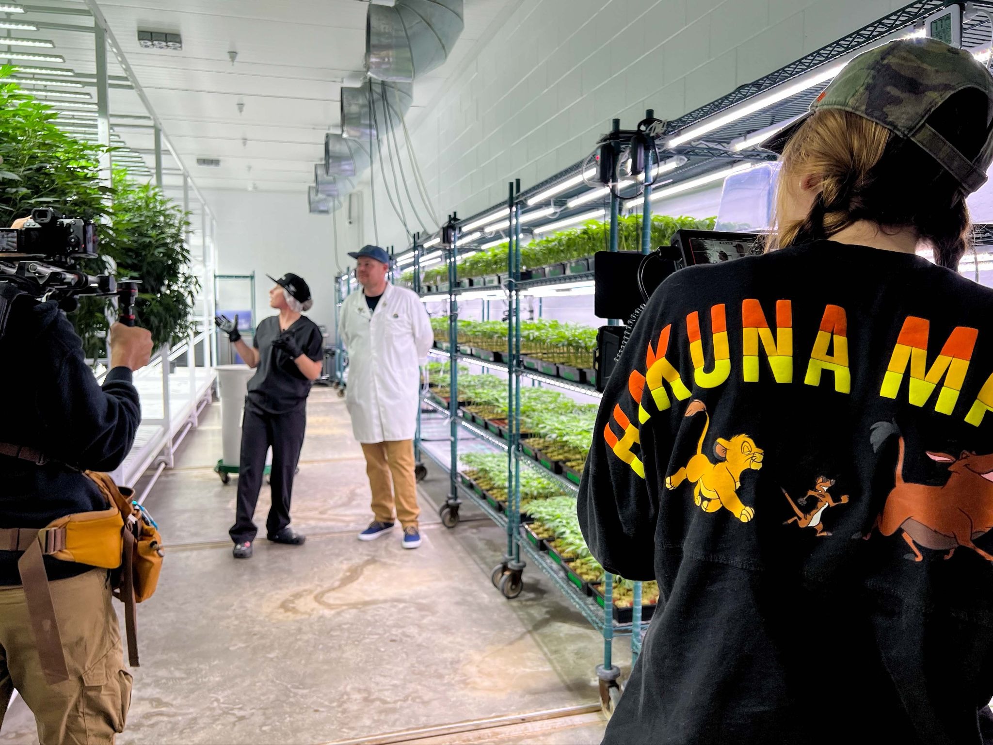 Roots & Reefer film crew in Hakuna Matata shirts filming inside Fort Smith, Arkansas medical marijuana cultivation facility.