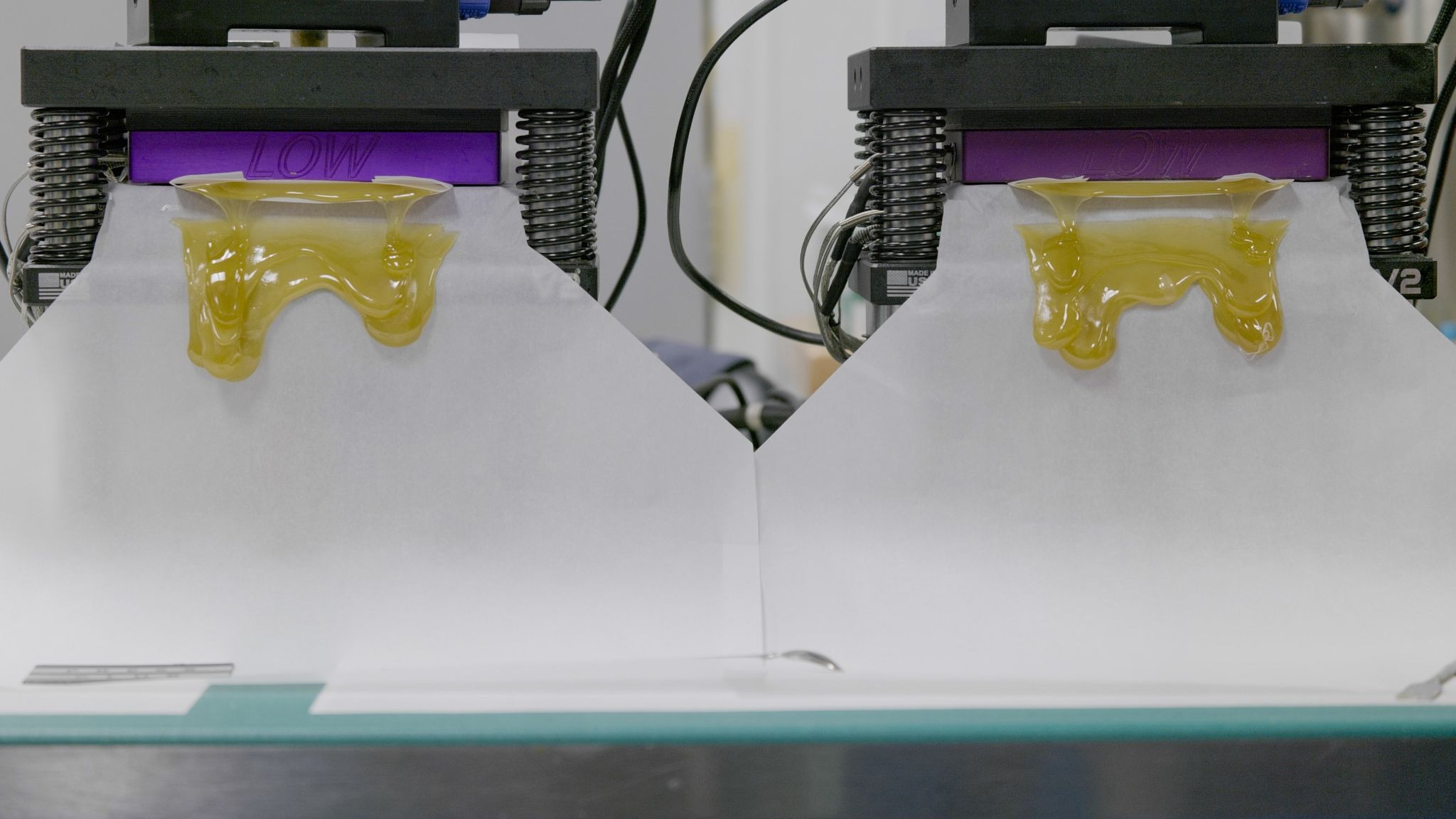 Golden cannabis oil being dispensed from extraction equipment at Arkansas medical marijuana production facility.