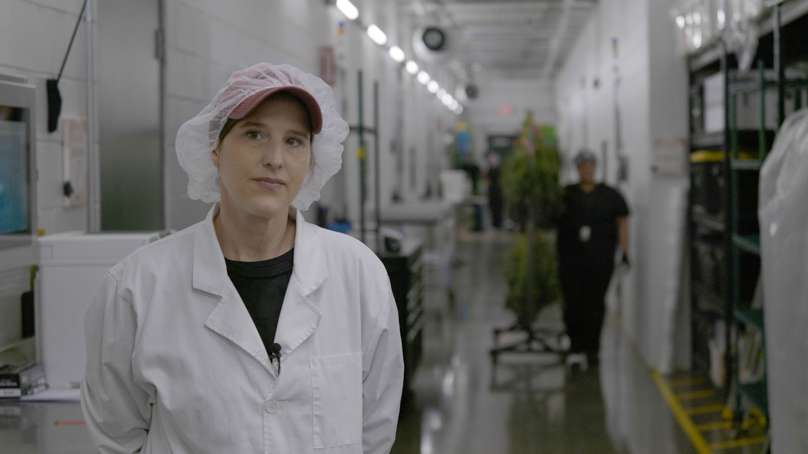 Kristi Hensley in white lab coat and hairnet inside RVR cannabis cultivation facility in Fort Smith, Arkansas.