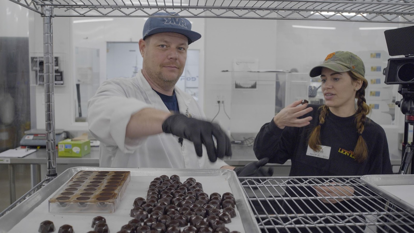 RVR President, Ryan Kenaga, in branded cap showing cannabis-infused chocolate truffles on cooling rack at River Valley Relief production facility in Fort Smith, Arkansas.