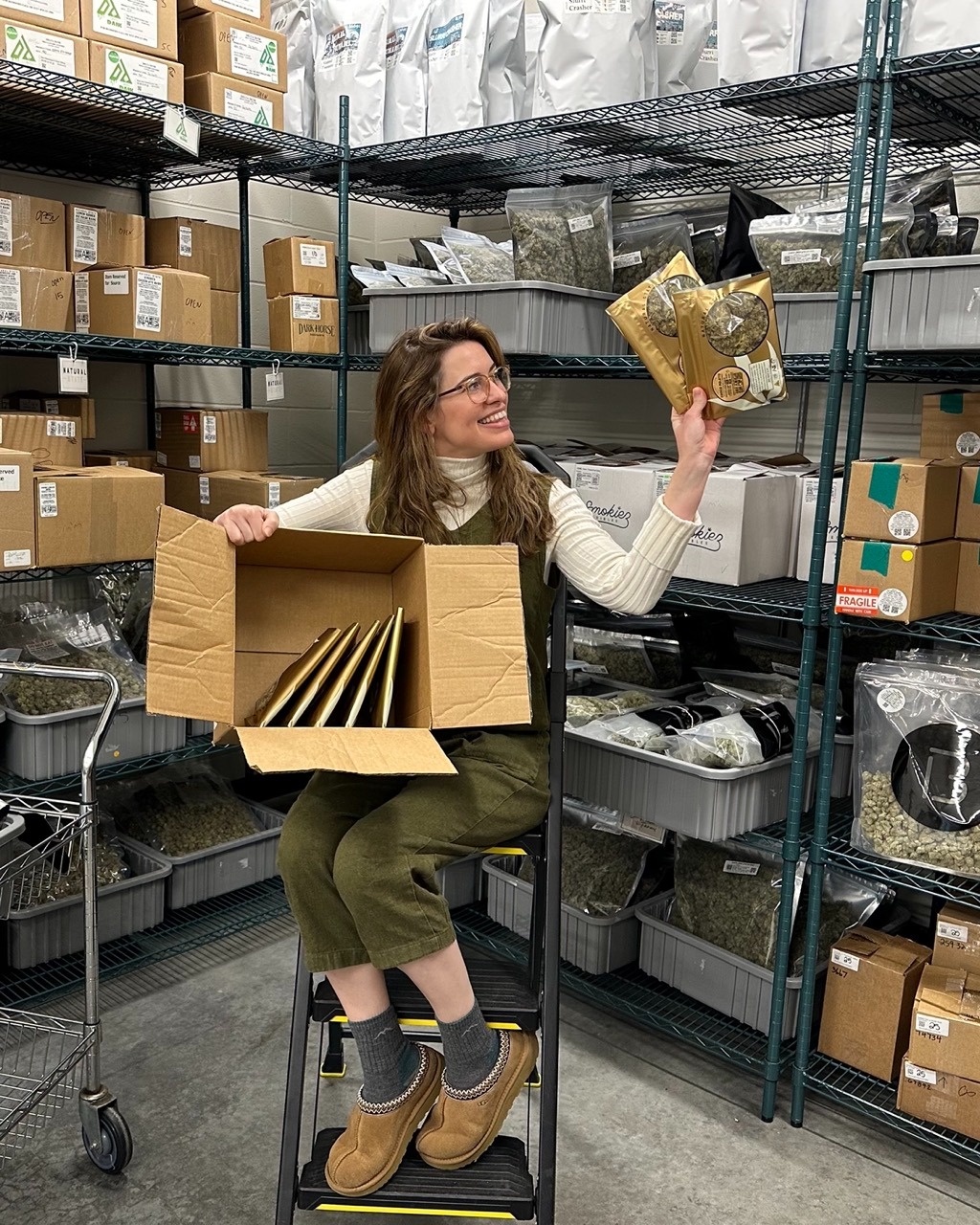 manda Strickland, CEO of The Source, sitting in inventory vault holding cannabis products for Vacate the Vault year-end sale.