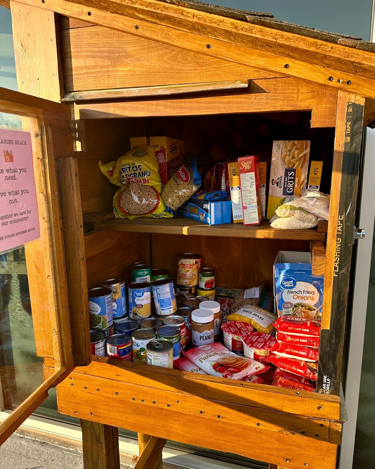 The Source Sharing Shack community pantry filled with donated canned goods and food items.