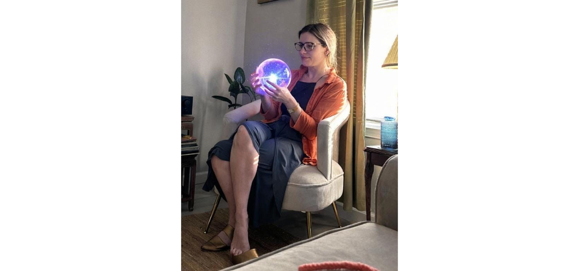 Amanda Strickland, CEO of The Source Dispensary & Apothecary in Rogers, Arkansas, holding a glowing crystal ball