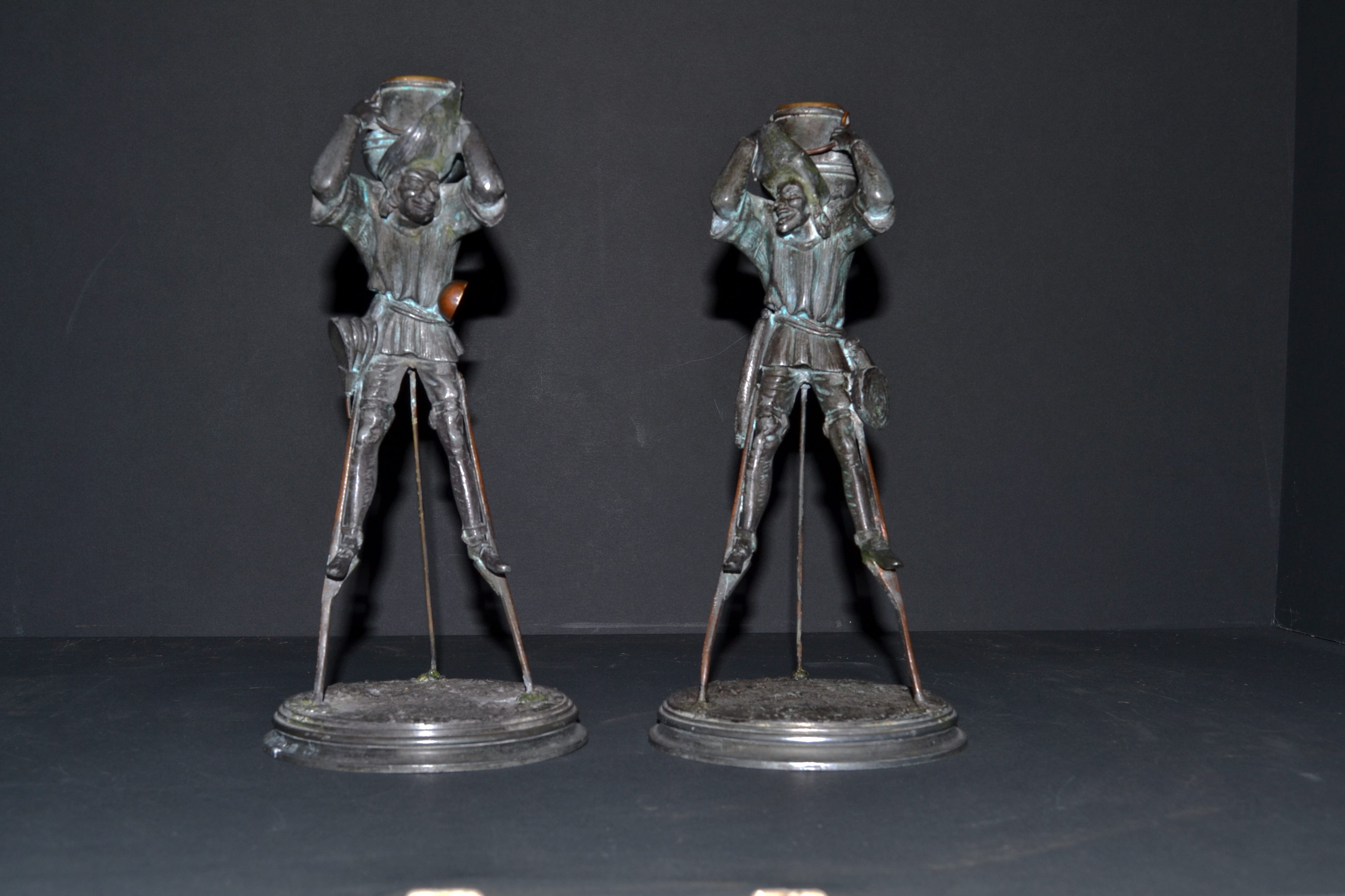 A fabulous Pair of bronze patinated spelter candlesticks in the form of Medievil characters on stilts.