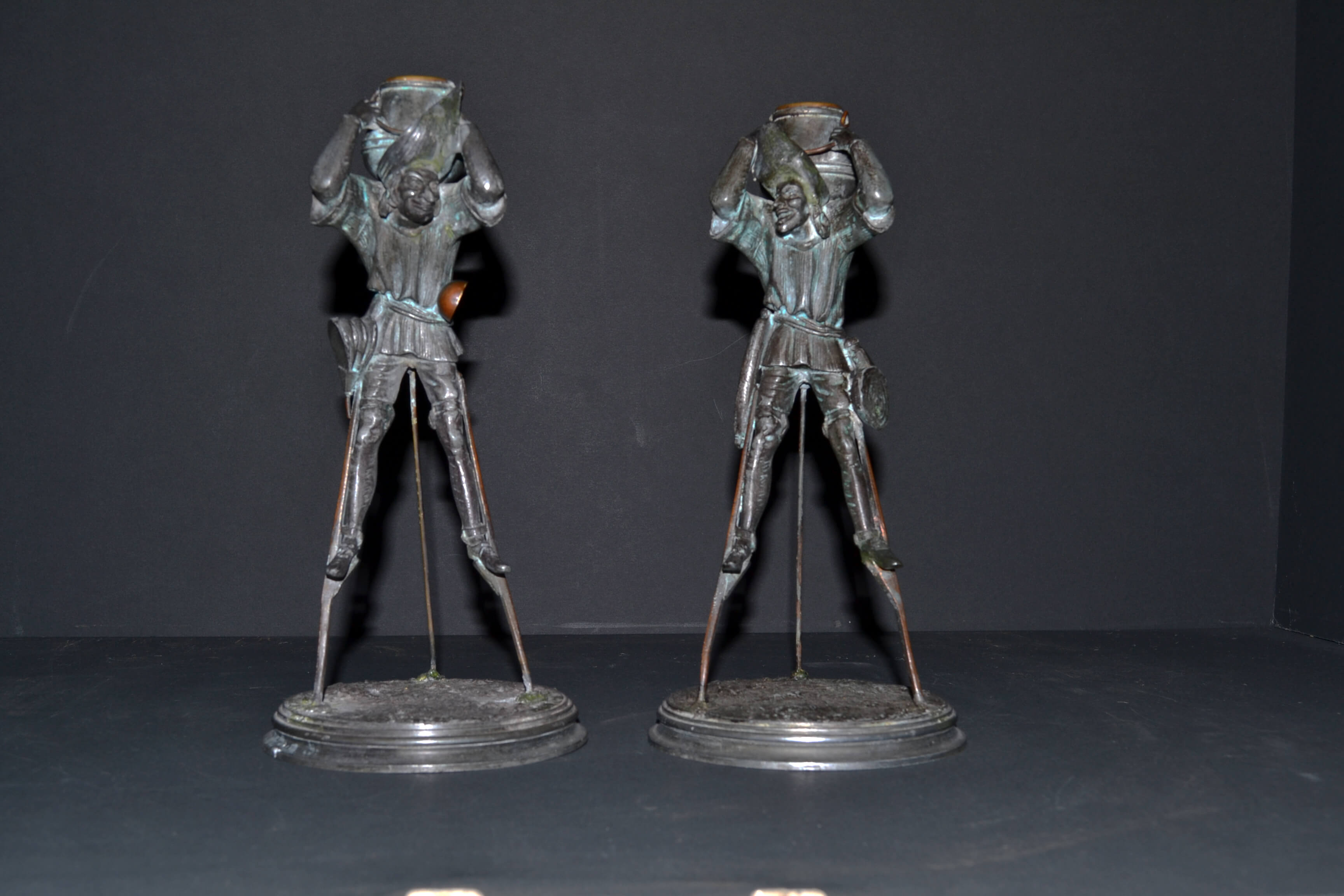 A fabulous Pair of bronze patinated spelter candlesticks in the form of Medievil characters on stilts.