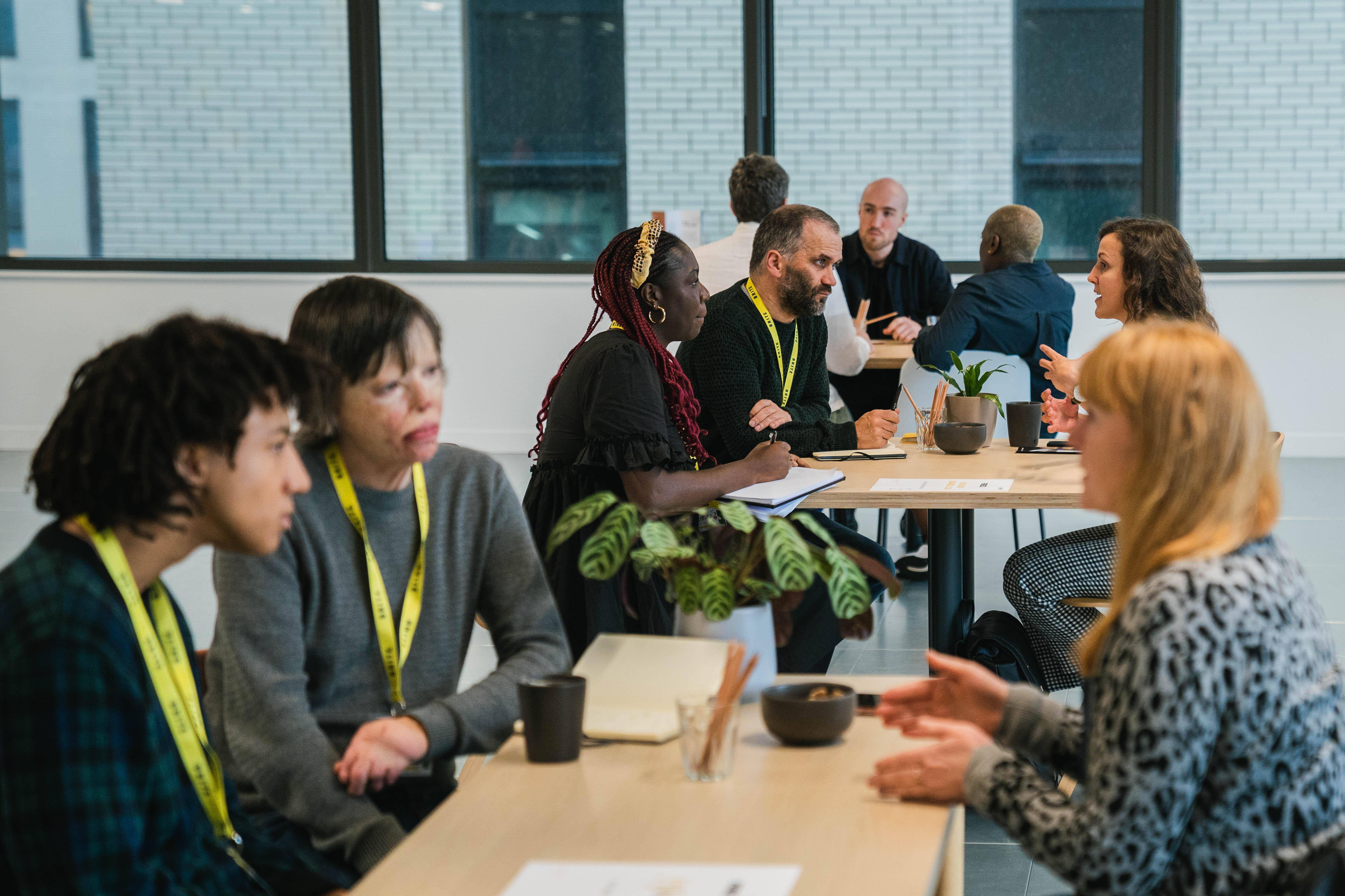 groups of people around small tables talking