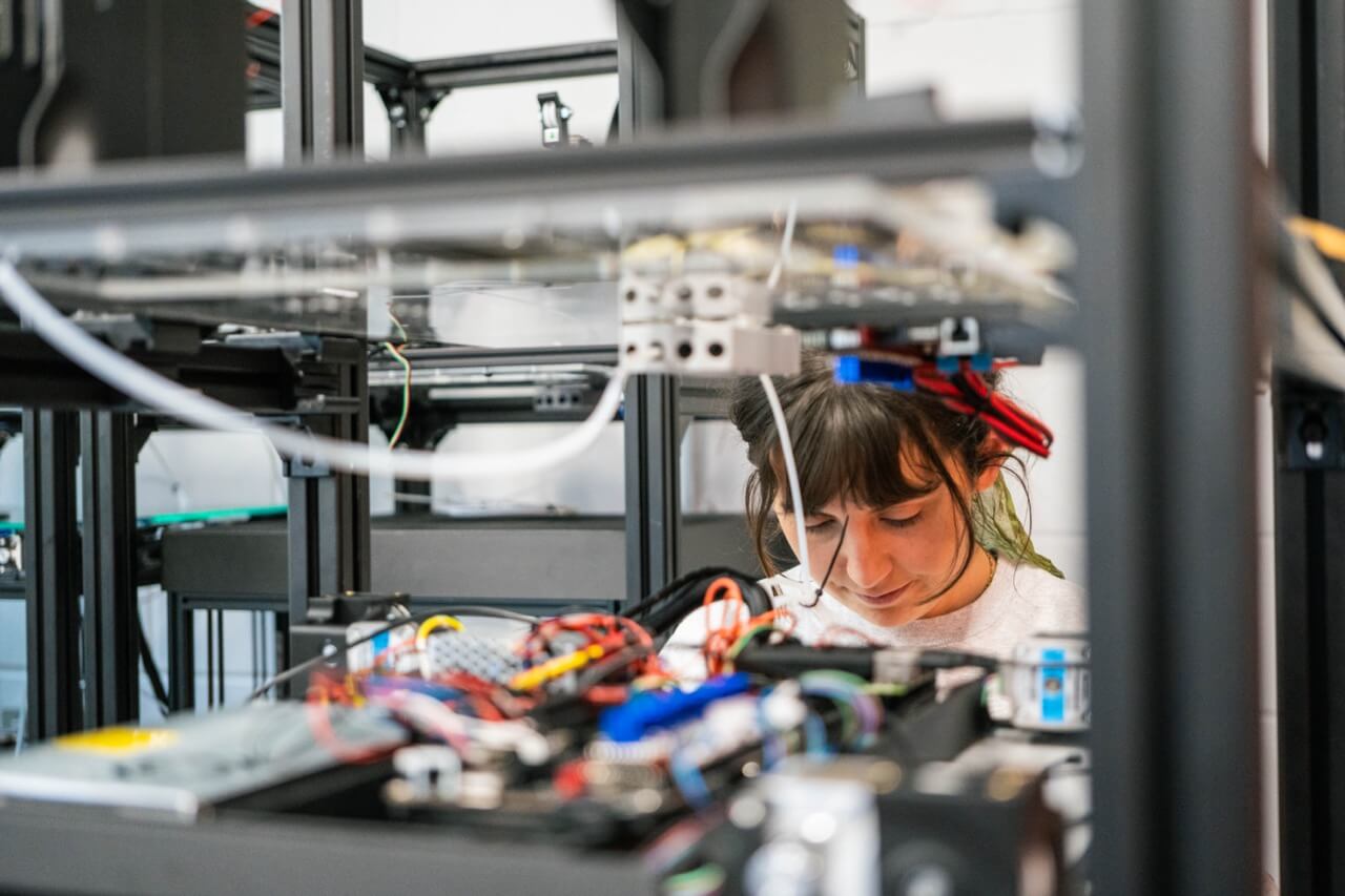 Woman using AI 3D printer at Plus X Innovation