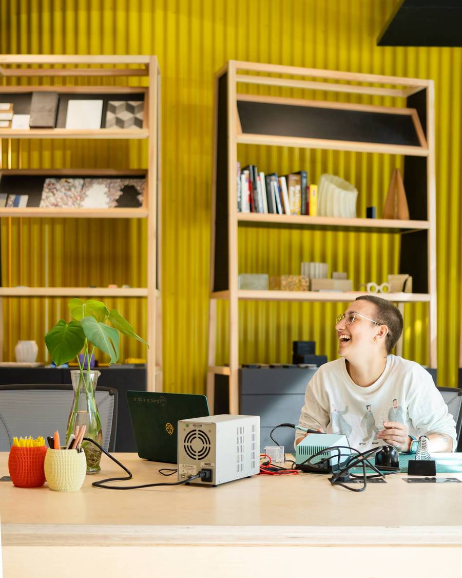A woman using a soldering iron in the workshop