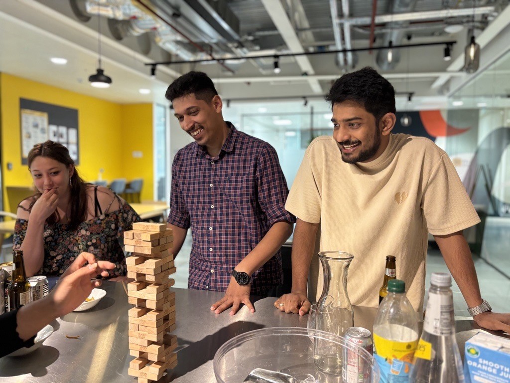 Plus X Innovation Members playing a game of Jenga .