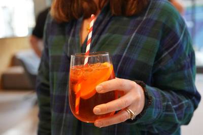 Plus X Innovation member holding an aperol spritz