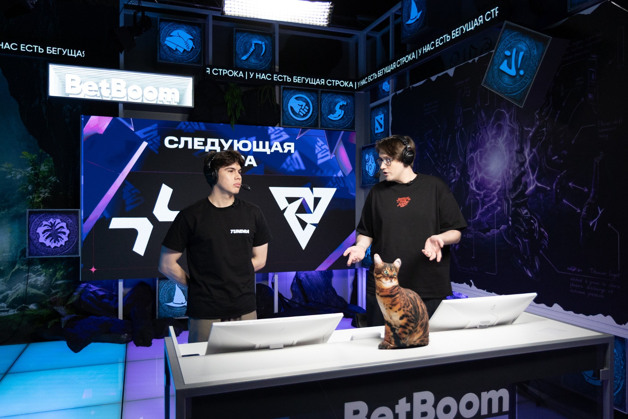 Two presenters and a cat at the BetBoom broadcast desk