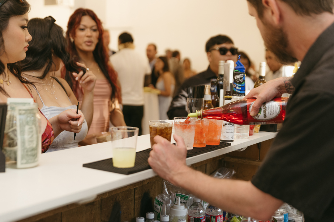 Wedding bartender pours cocktail for guests.