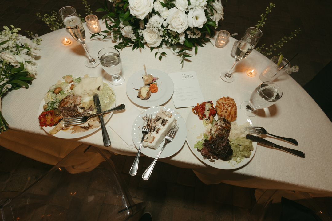 Wedding recpetion dinner plates filled with catered chicken, short rib, beef wellingtons, salad, tortellini, and mashed potatoes.