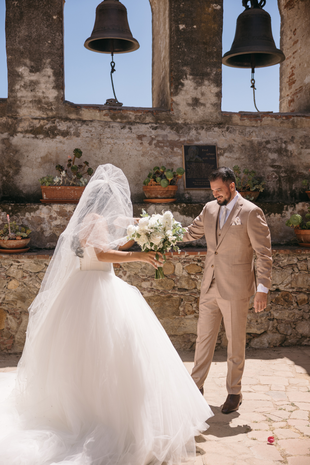 Groom smiles when he sees the bride for their first look at Mission San Juan Capistrano.