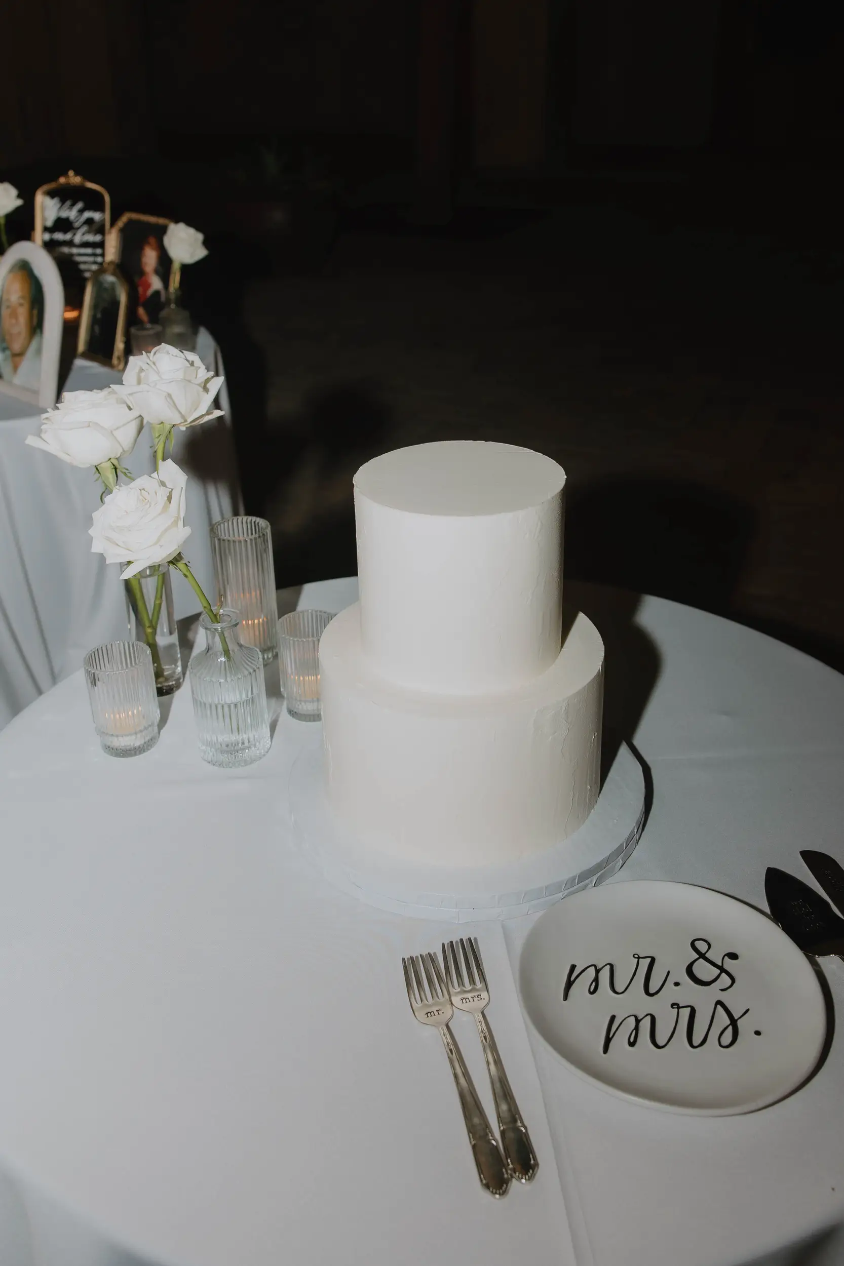 Two-tier wedding cake on cake table waiting to be cut.